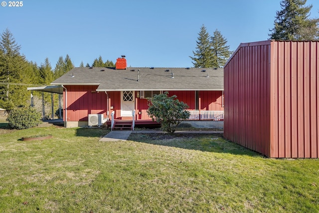 back of house with ac unit and a lawn