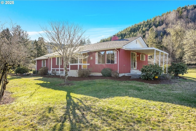 ranch-style house featuring a mountain view, a front lawn, and a porch