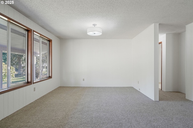 unfurnished room with a textured ceiling and carpet flooring