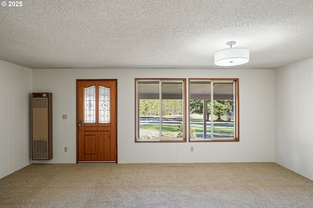 carpeted foyer entrance featuring a textured ceiling