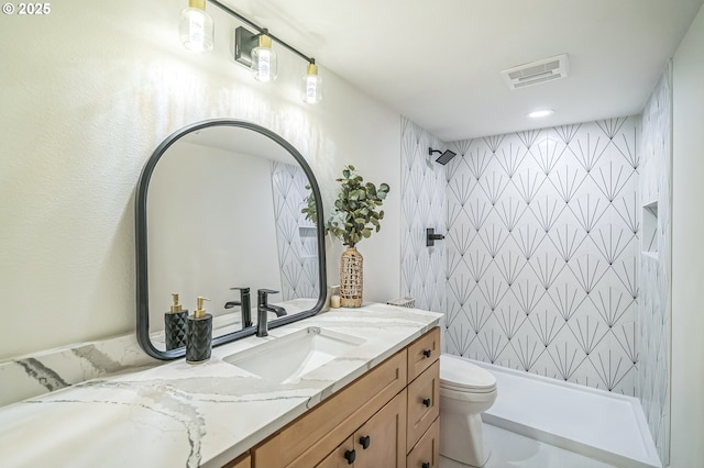 bathroom with a shower, toilet, and vanity