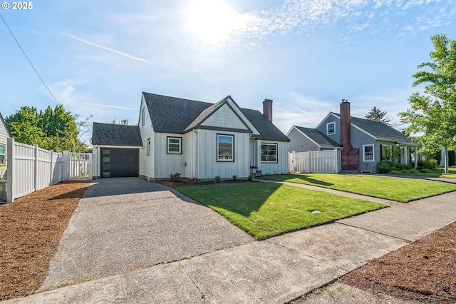 view of front of property with board and batten siding, asphalt driveway, a garage, and roof with shingles