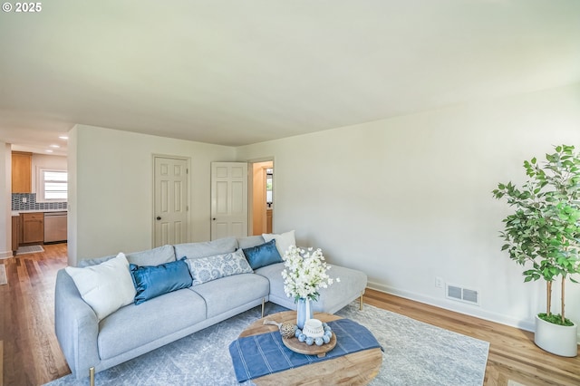 living area featuring wood finished floors, baseboards, and recessed lighting