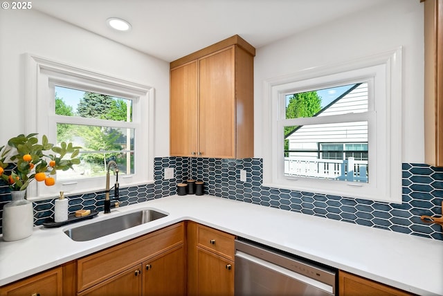 kitchen featuring dishwasher, a sink, tasteful backsplash, light countertops, and recessed lighting