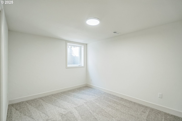 carpeted spare room featuring baseboards