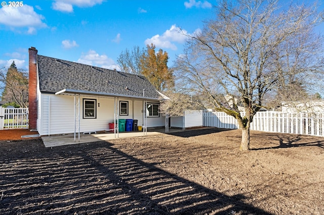 rear view of property with fence and a patio