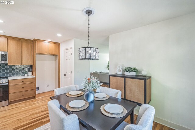 dining space with light wood-style floors, a chandelier, and recessed lighting