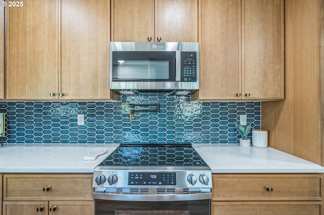 kitchen featuring stainless steel appliances, light countertops, decorative backsplash, and light brown cabinets