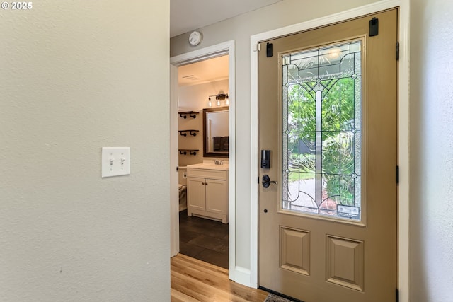 319 NE Hyde Cir, Hillsboro, OR 97124 - doorway to outside with light wood-type flooring, a sink, and baseboards