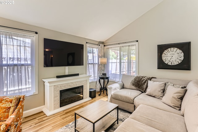 319 NE Hyde Cir, Hillsboro, OR 97124 - living area featuring wood finished floors, baseboards, lofted ceiling, and a glass covered fireplace