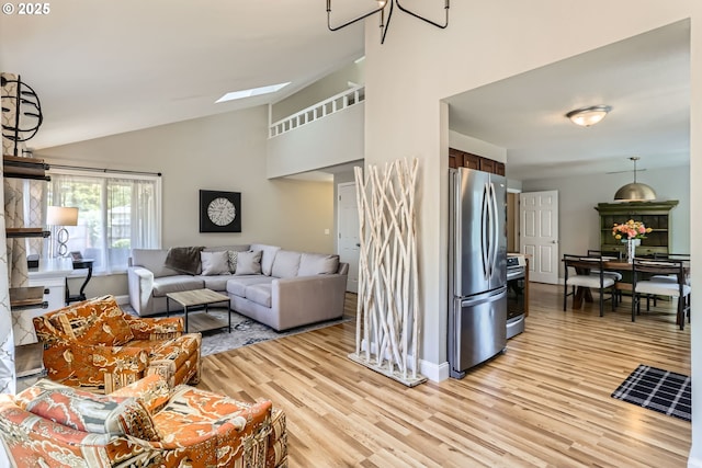 319 NE Hyde Cir, Hillsboro, OR 97124 - living room with light wood-style flooring, lofted ceiling, baseboards, and a skylight