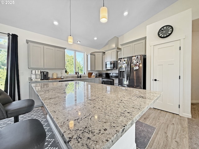 7205 Edge Cliff Dr, Brookings, OR 97415 - kitchen with appliances with stainless steel finishes, gray cabinetry, light stone countertops, vaulted ceiling, and decorative light fixtures