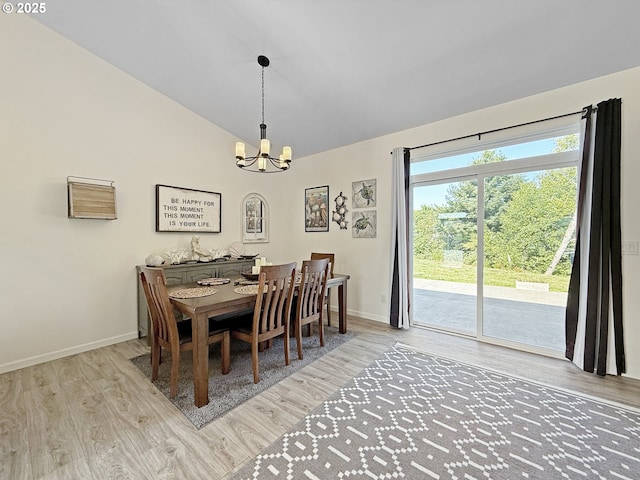7205 Edge Cliff Dr, Brookings, OR 97415 - dining space featuring a chandelier, wood finished floors, baseboards, and high vaulted ceiling