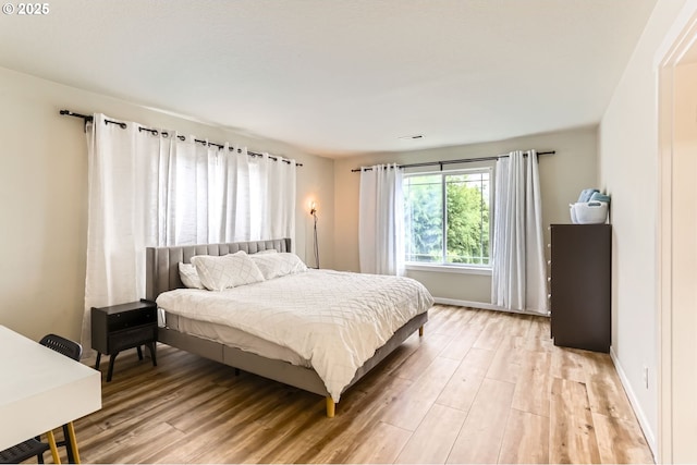 bedroom with light wood-style flooring and baseboards