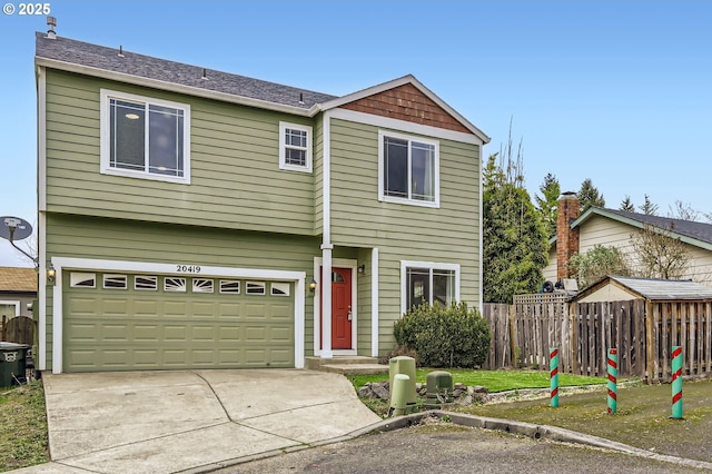 view of front of property with a garage, concrete driveway, and fence