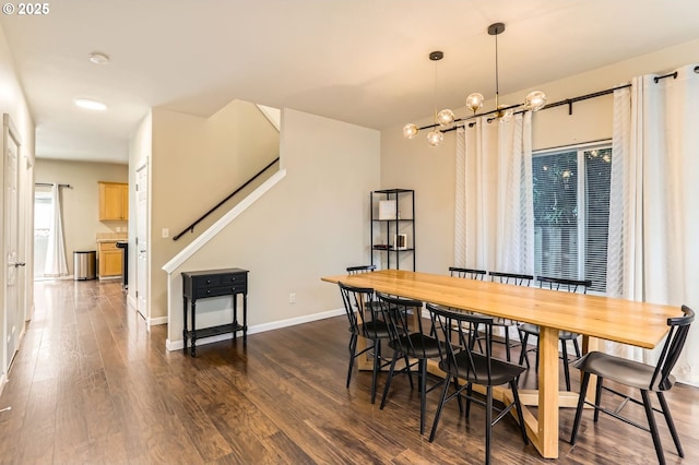 dining area with baseboards, dark wood finished floors, and an inviting chandelier