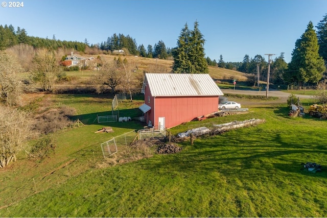 view of outbuilding featuring a rural view and a yard