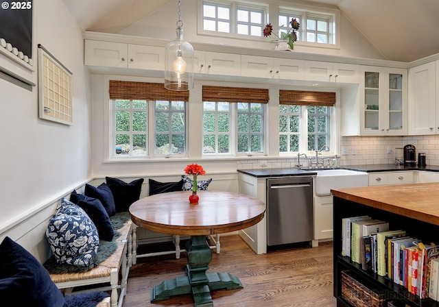 kitchen with sink, white cabinetry, dishwasher, decorative backsplash, and hanging light fixtures