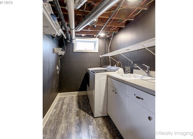 clothes washing area with sink, dark hardwood / wood-style flooring, cabinets, and independent washer and dryer