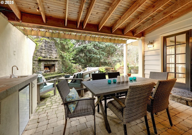 view of patio with sink and an outdoor stone fireplace