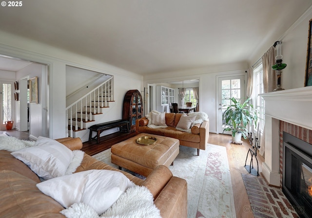 living room featuring a brick fireplace and wood-type flooring