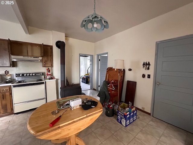 kitchen with decorative light fixtures, dark brown cabinets, and white electric range