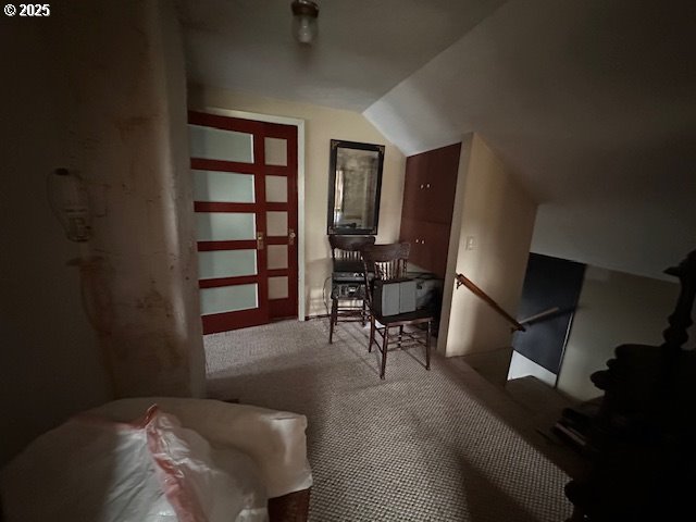 bonus room with vaulted ceiling and carpet flooring