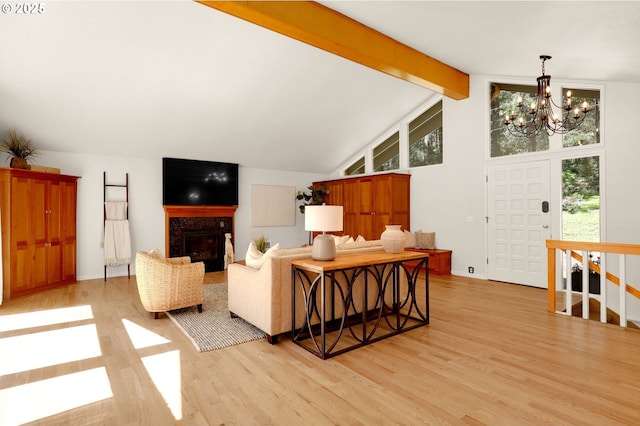 living area with light wood finished floors, vaulted ceiling with beams, visible vents, and a fireplace