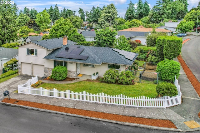 1520 SE 109th Ave, Portland, OR 97216 - view of front of home featuring an attached garage, a shingled roof, roof mounted solar panels, concrete driveway, and stone siding