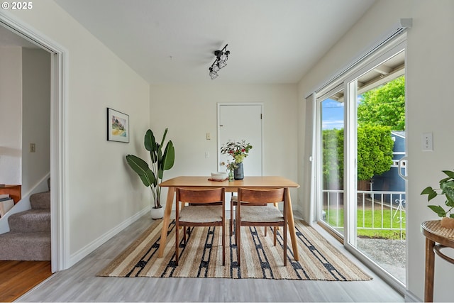 1520 SE 109th Ave, Portland, OR 97216 - dining space with light wood-style floors, stairs, track lighting, and baseboards