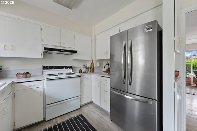 1520 SE 109th Ave, Portland, OR 97216 - kitchen with freestanding refrigerator, under cabinet range hood, white range with electric stovetop, light wood-type flooring, and light countertops