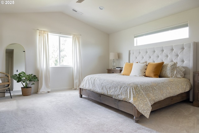 bedroom featuring arched walkways, lofted ceiling, carpet floors, and baseboards