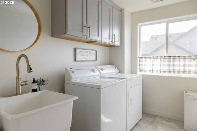 washroom with washing machine and clothes dryer, cabinet space, and baseboards