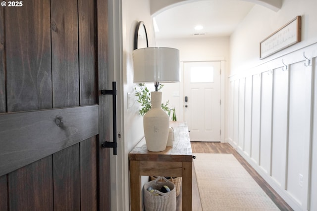 doorway to outside with arched walkways and wood finished floors