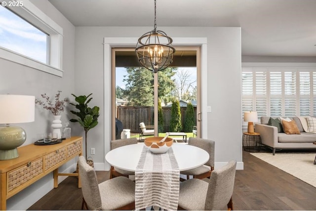 dining area with an inviting chandelier and dark hardwood / wood-style floors