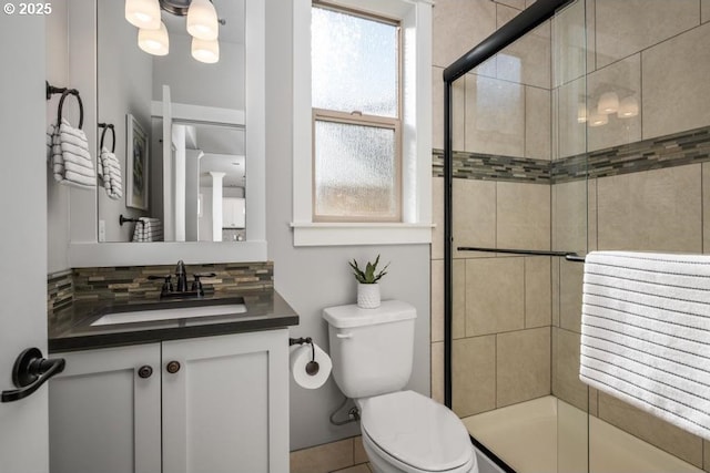 bathroom featuring vanity, an enclosed shower, and toilet