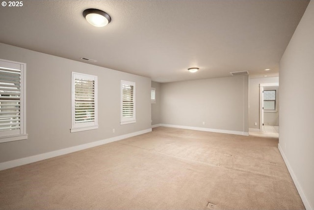 empty room featuring light carpet and a textured ceiling