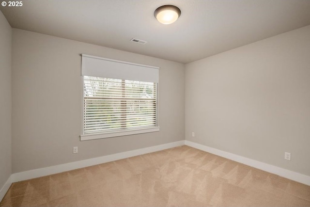 spare room featuring light colored carpet