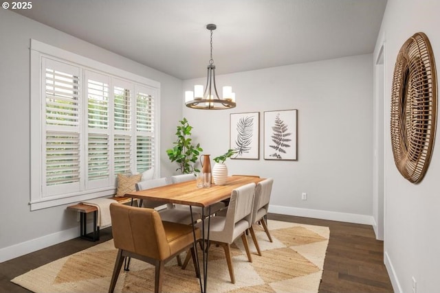 dining area with dark hardwood / wood-style floors and a chandelier