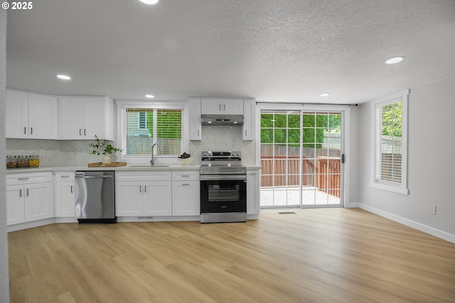 1111 SW Linneman Ave, Gresham, OR 97080 - kitchen with appliances with stainless steel finishes, under cabinet range hood, tasteful backsplash, light countertops, and recessed lighting