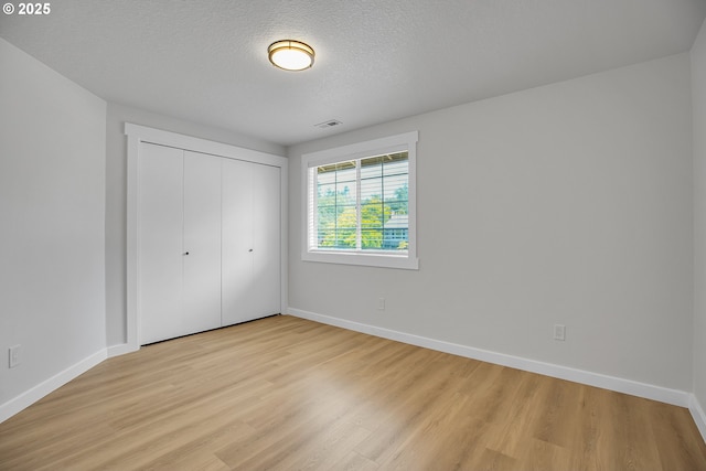 1111 SW Linneman Ave, Gresham, OR 97080 - unfurnished bedroom featuring light wood-style flooring, a closet, and a textured ceiling
