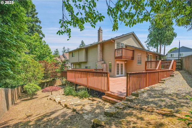 1111 SW Linneman Ave, Gresham, OR 97080 - rear view of property featuring a balcony, a fenced backyard, a chimney, a wooden deck, and french doors