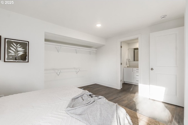 bedroom with dark hardwood / wood-style flooring, a closet, and connected bathroom