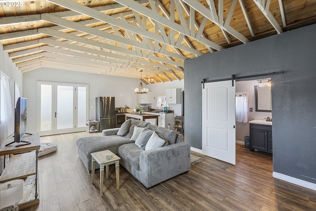 11868 N Jantzen Dr, Portland, OR 97217 - living room featuring a barn door, dark wood-type flooring, a chandelier, and baseboards