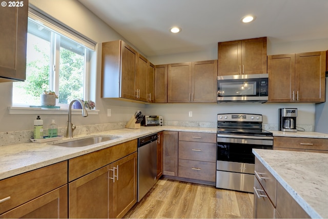 1637 E 21st St, The Dalles, OR 97058 - kitchen featuring appliances with stainless steel finishes, a sink, light stone countertops, recessed lighting, and light wood-style flooring