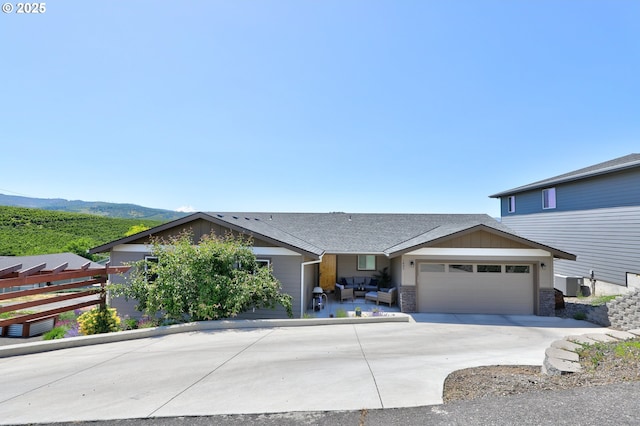 1637 E 21st St, The Dalles, OR 97058 - view of front of home featuring an attached garage, driveway, an outdoor living space, central AC unit, and a shingled roof