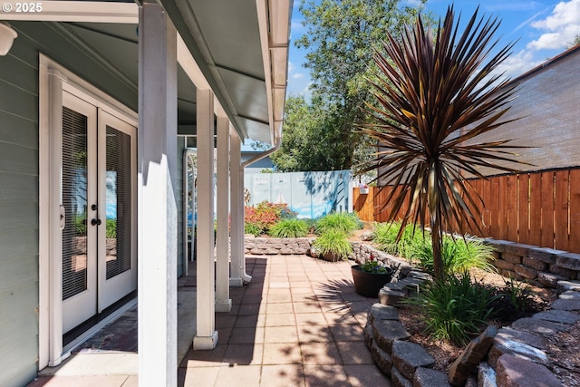 view of patio with french doors and fence