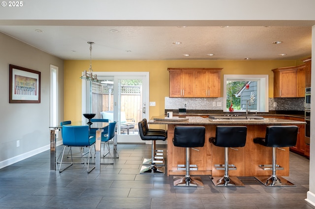 11782 SE 108th Ave, Happy Valley, OR 97086 - kitchen with tasteful backsplash, plenty of natural light, a chandelier, a kitchen bar, and recessed lighting