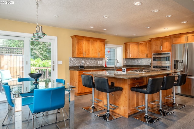 11782 SE 108th Ave, Happy Valley, OR 97086 - kitchen featuring stainless steel appliances, decorative backsplash, a textured ceiling, a center island, and recessed lighting