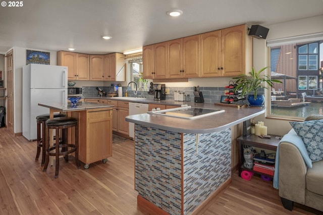 429 N Bridgeton Rd # 15, Portland, OR 97217 - kitchen featuring a breakfast bar, freestanding refrigerator, light brown cabinets, light wood-type flooring, and recessed lighting